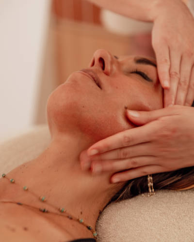 Close-up of a person receiving a relaxing facial massage at a spa.