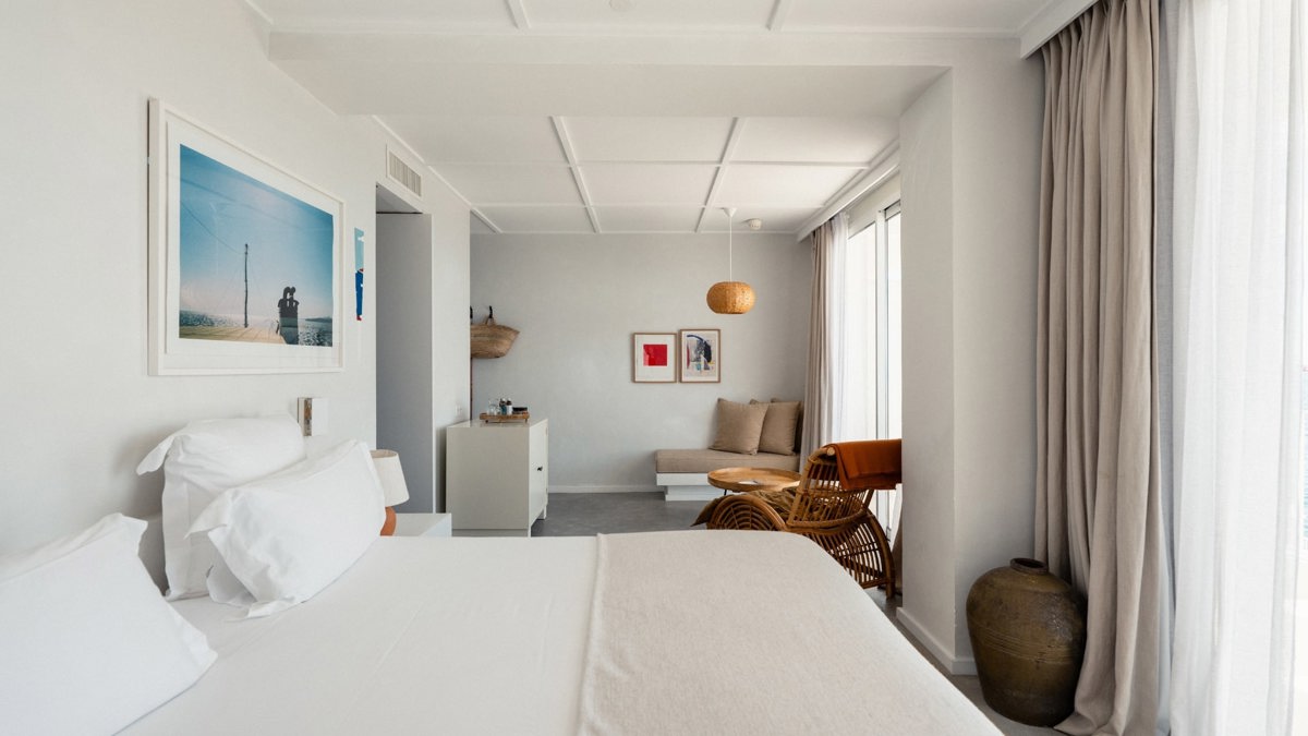 A well-organized bedroom features a cozy bed, a nearby chair, and a portrait mounted above.