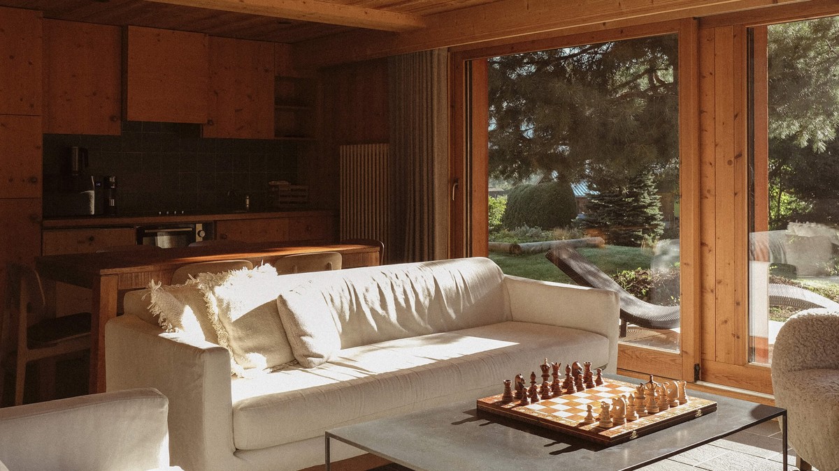 A photo of the living space shows a cozy sofa set near a large window.