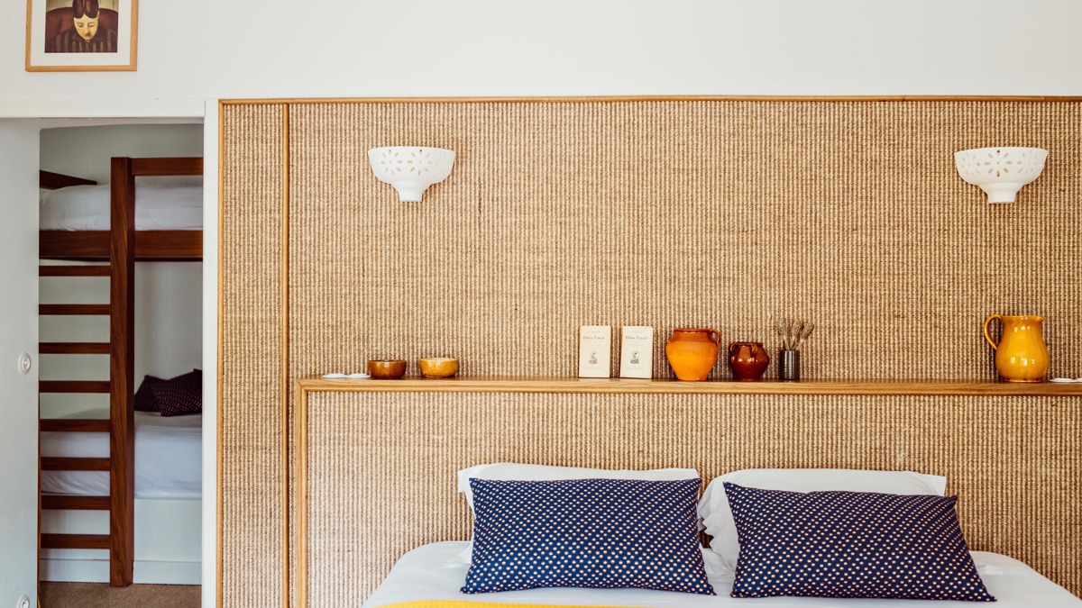 Une chambre bien agencée comprend un lit douillet avec des objets décoratifs placés sur la tête de lit.