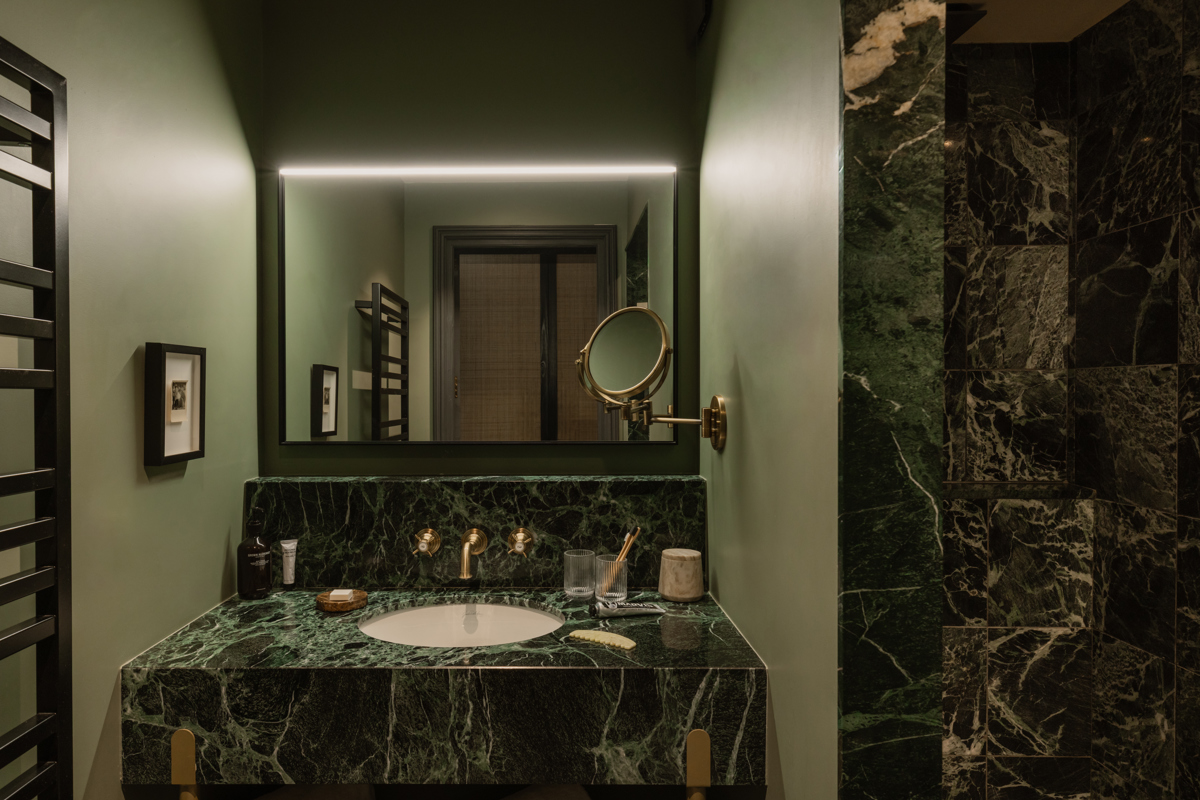 Salle de bains du Fitz Roy à Val Thorens, vasque en marbre vert, robinetterie laiton et miroir rétroéclairé