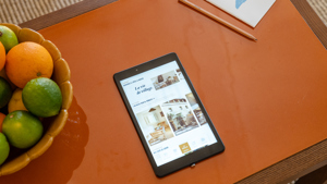 Une photo aérienne prise montre un iPad sur la table à côté d'une corbeille de fruits.