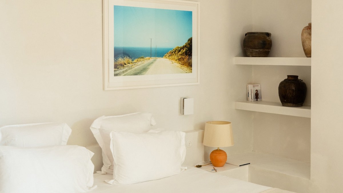 A side table holds a small lamp, with a portrait mounted just above the table.