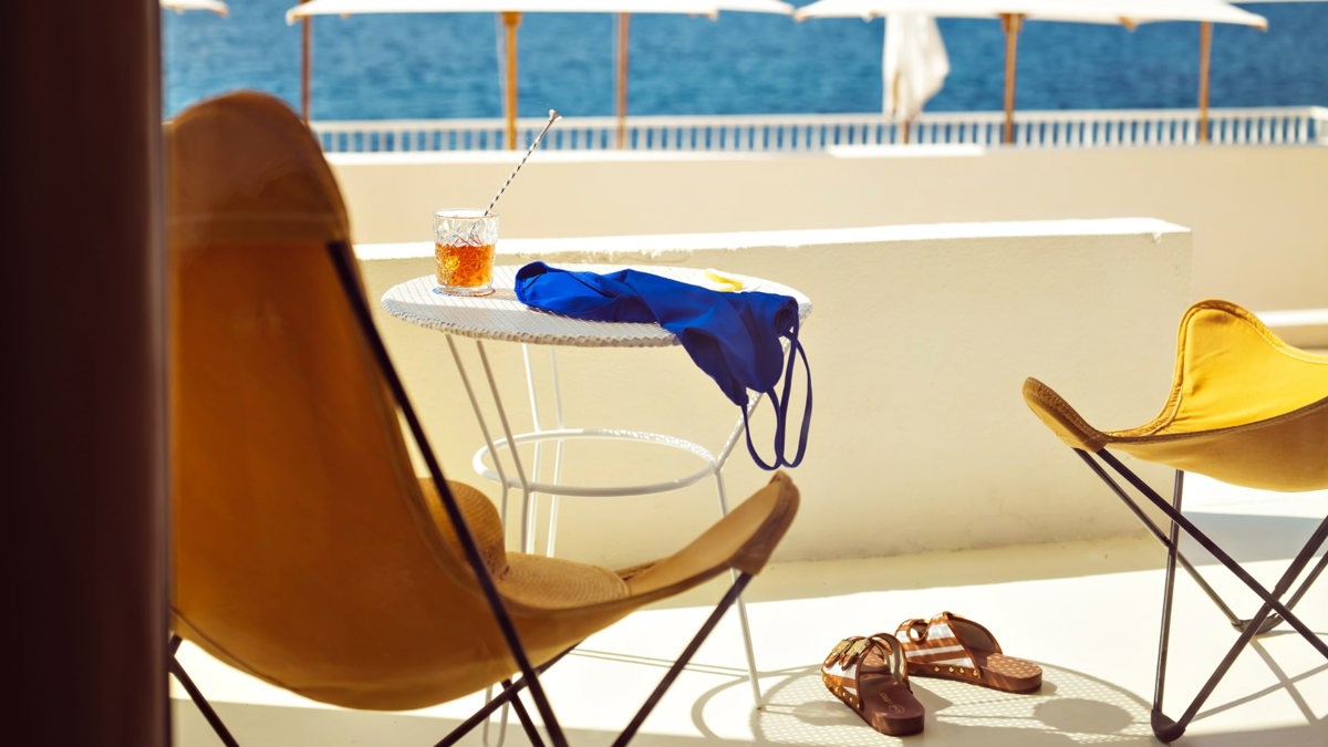 Two chairs with a table are placed on the balcony, offering an awesome sea view.