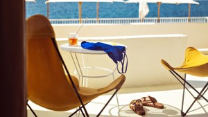 Two chairs with a table are placed on the balcony, offering an awesome sea view.