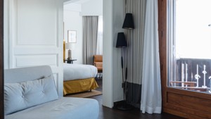 A two-framed stand lamp is placed by the door connecting the living space and bedroom.