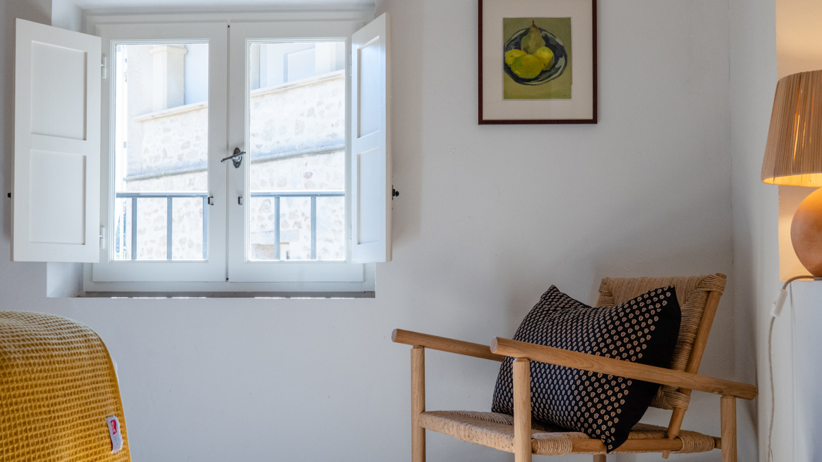 Une chaise confortable est placée près de la fenêtre en verre avec un portrait monté au-dessus.