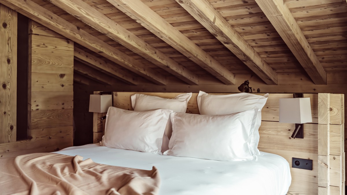 A clicked photo shows a cozy bed accompanied by four soft, comfortable pillows.