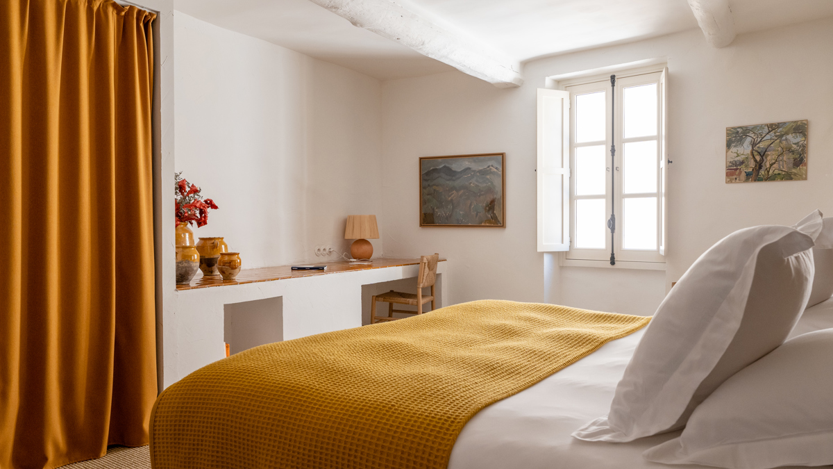 Objets décoratifs et carnet disposés sur étagères murales avec deux portraits adjacents.