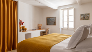 Objets décoratifs et carnet disposés sur étagères murales avec deux portraits adjacents.