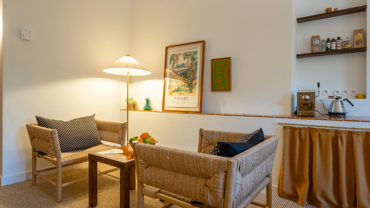 Une paire de chaises confortables avec une table dans le coin et un portrait à côté du lampadaire.