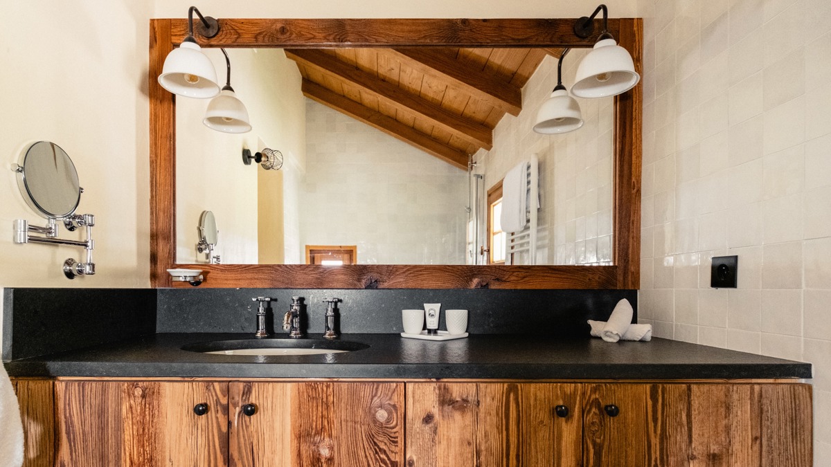 Modern bathroom with a freestanding bathtub, double sinks, large mirror, and soft natural lighting.