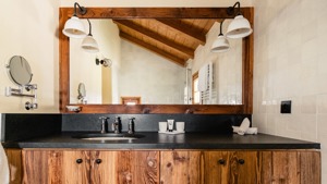 Modern bathroom with a freestanding bathtub, double sinks, large mirror, and soft natural lighting.