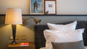 Deux portraits sont placés au-dessus de la tête de lit, avec une table d’appoint contenant l’essentiel.